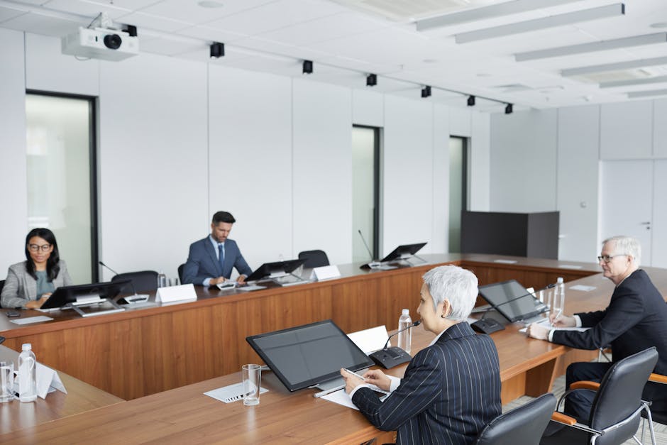 Diverse group of business professionals in a conference room engaged in a meeting.